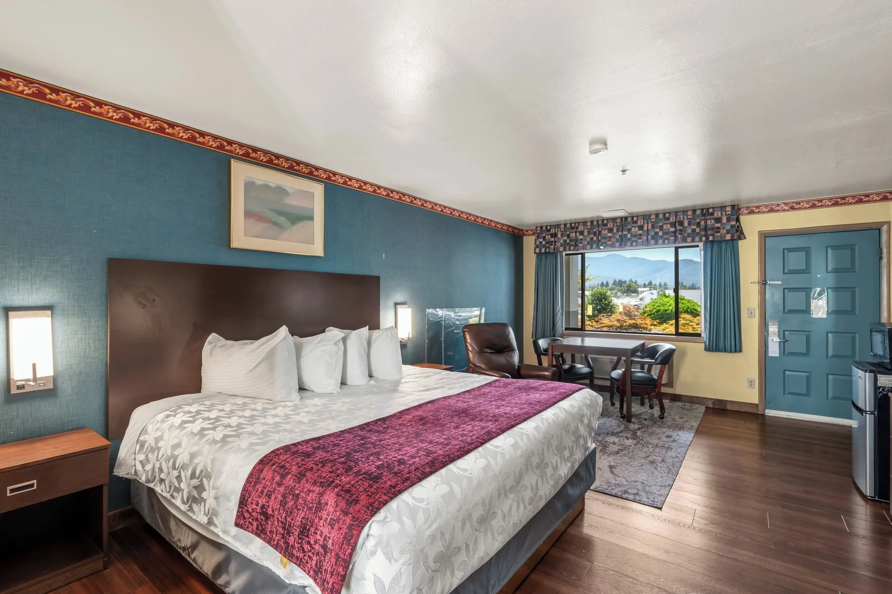 King guest room with a bed, seating, and a desk